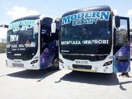 White and blue coach bus parked on a sunny street, displaying Nairobi destination signage