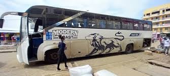 Modern Tours intercity coach bus parked at a transport terminal with passengers boarding