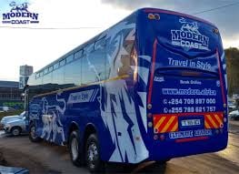 Blue and white double-decker travel bus with Modern Travels branding parked in lot